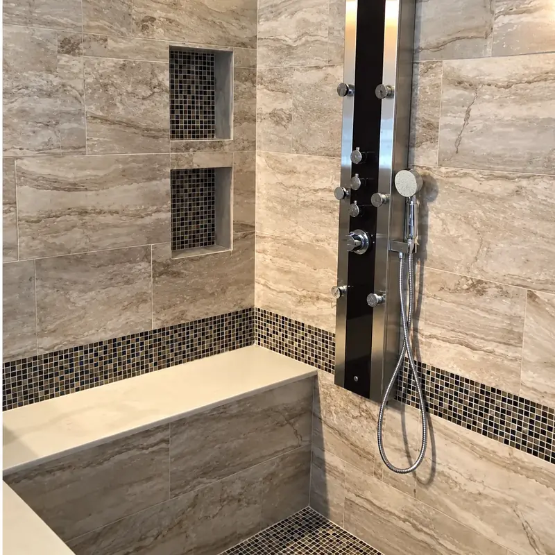 Tiled shower remodel with a jetted shower panel and built in bench